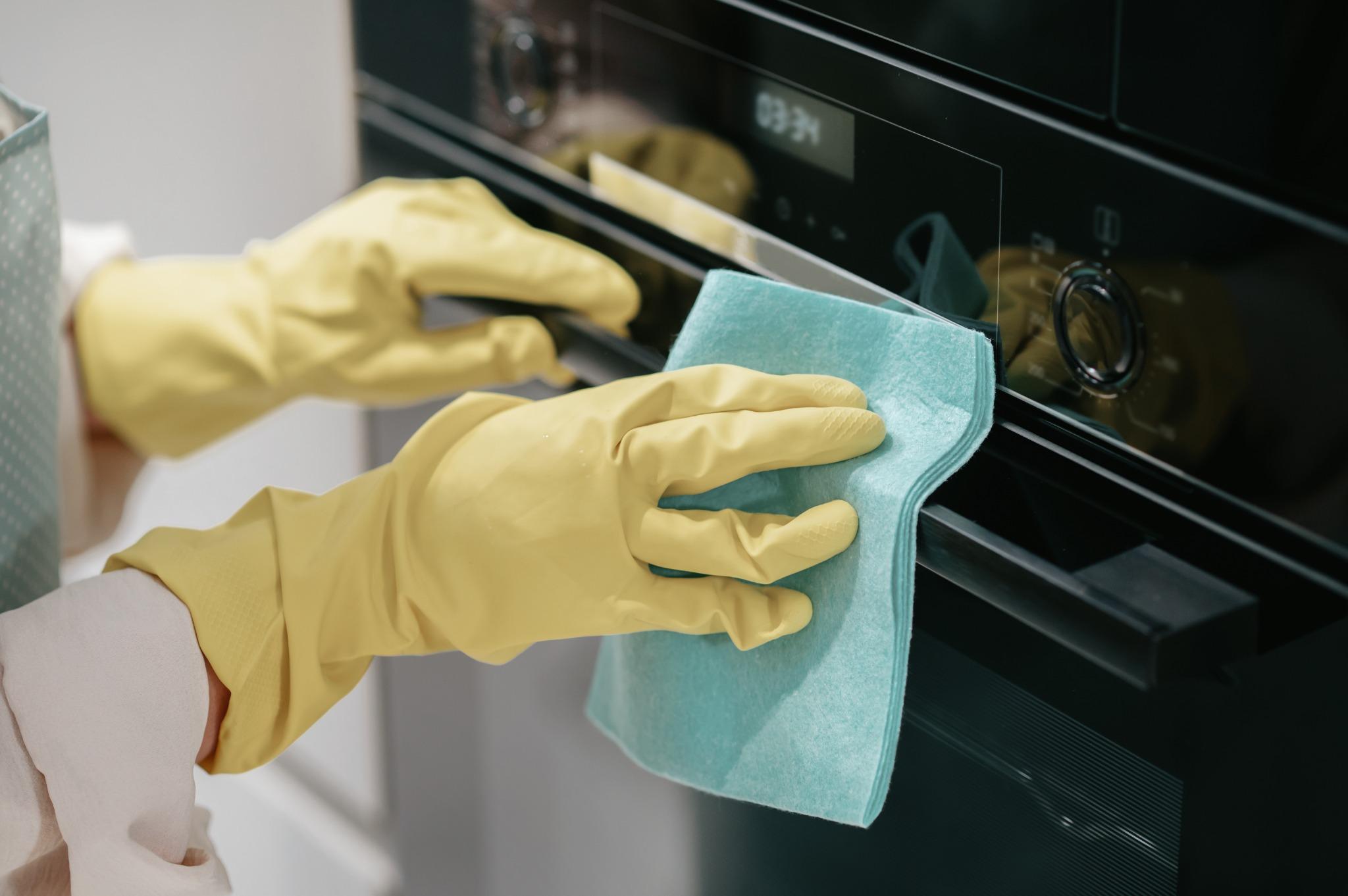 Close-up of professional kitchen appliance cleaning with gloves in London home